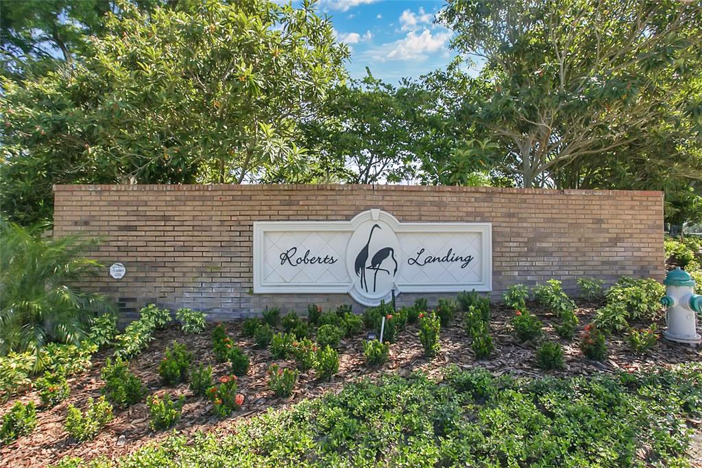 A brick wall with a sign reading Roberts Landing sits in front of lush trees — 1661 ROBERTS LANDING ROAD, WINDERMERE, FL