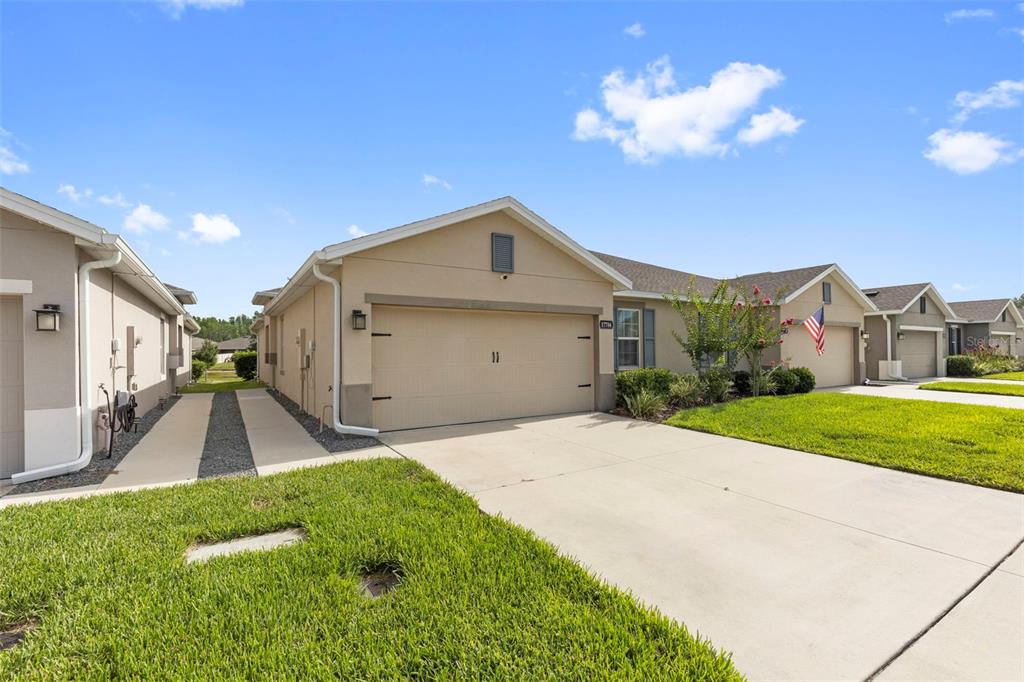 A beige single-story house with a two-car garage and a concrete driveway — 17784 TURNING LEAF CIRCLE, LAND O LAKES, FL