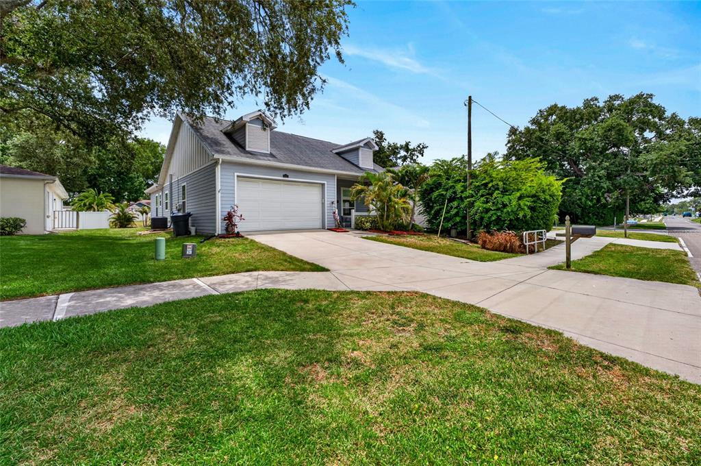 A light blue house with a two-car garage and a concrete driveway — 1535 PINEHURST ROAD, DUNEDIN, FL