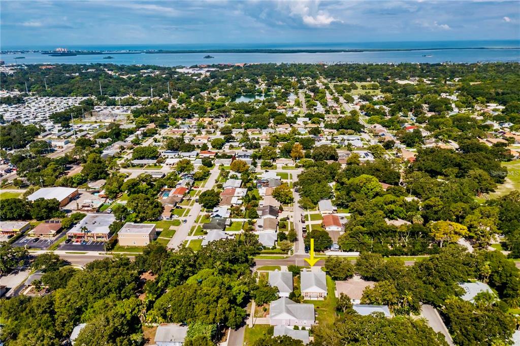 An aerial view shows a residential neighborhood with a yellow arrow pointing to a house — 1535 PINEHURST ROAD, DUNEDIN, FL