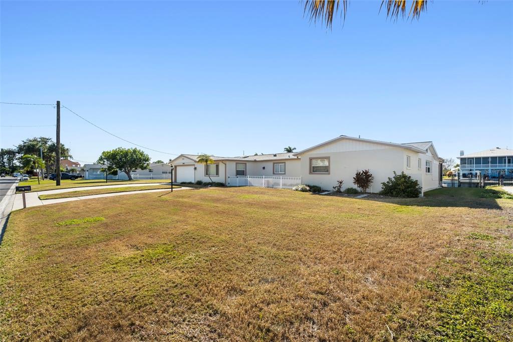 A single-story house with a light-colored exterior sits on a large, dry grassy lot — 5003 COMMONWEALTH ROAD, PALMETTO, FL