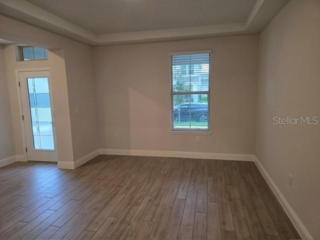 An entryway features a wooden staircase with iron railings, light-colored walls, and wood-look tile flooring — 11827 SHINE VIEW LANE, WINTER GARDEN, FL