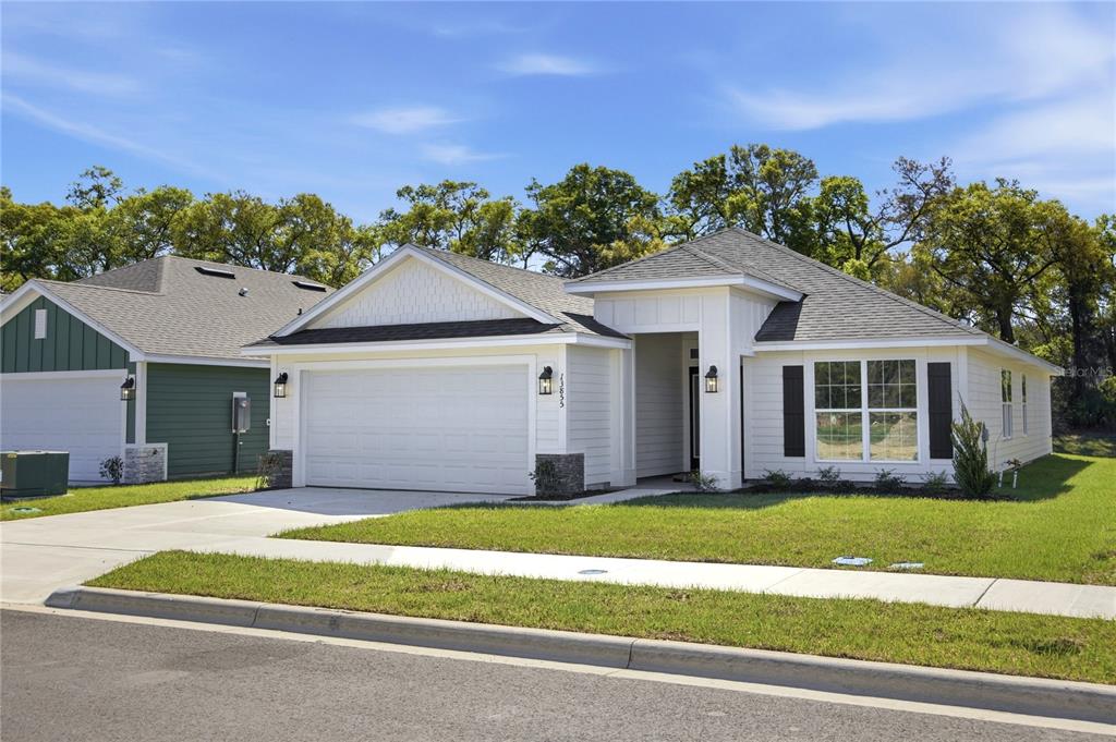 A single-story house with a two-car garage, stone accents, and a covered front porch — 16840 NW 178TH TERRACE, ALACHUA, FL