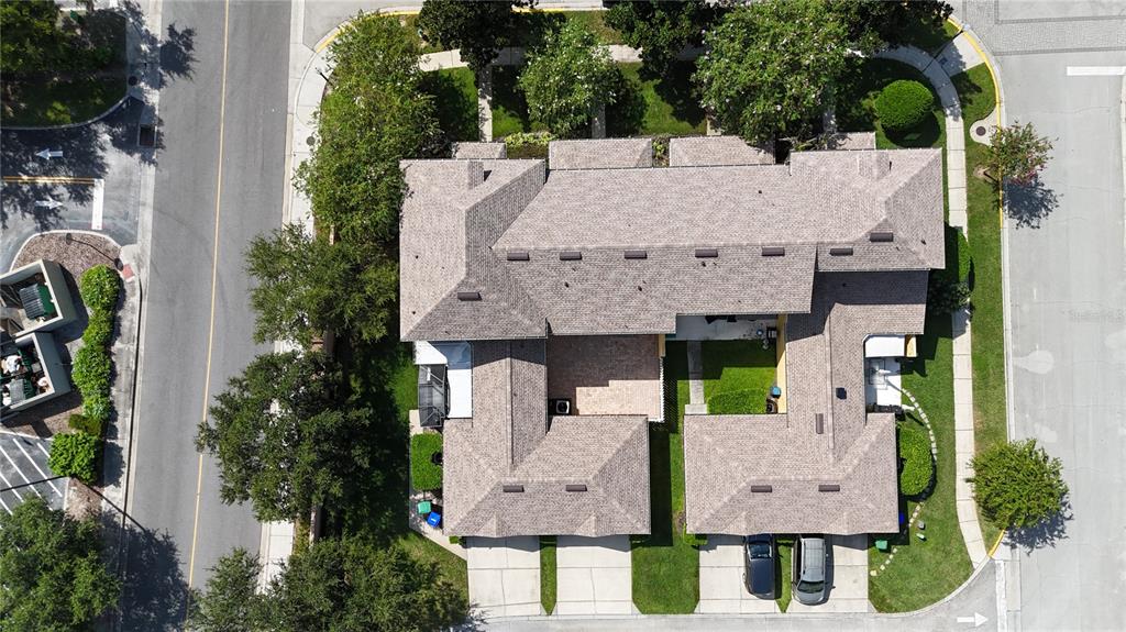 An aerial view shows a multi-unit residential building with shingled roofs and attached garages — 13851 BEAUREGARD PLACE, ORLANDO, FL