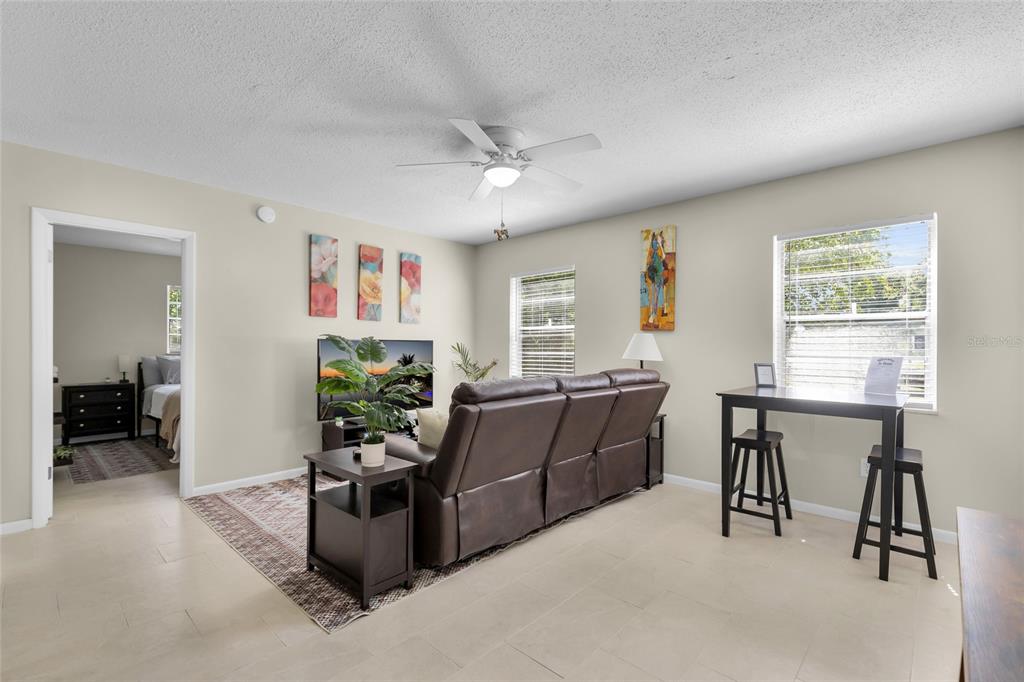 An empty room features light gray walls, wood-look tile flooring, and a ceiling fan — 2621 SW 33 AVENUE, OCALA, FL
