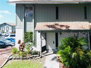 A two-story townhouse exterior with a front walkway, landscaping, and a shingled roof — 1960 UNION STREET UNIT 25, CLEARWATER, FL
