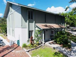 A two-story building with light green siding, a shingled roof, and a small front garden — 1960 UNION STREET UNIT 25, CLEARWATER, FL