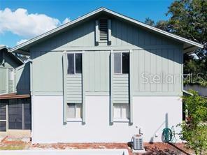 The exterior of a two-story house features light green siding, white stucco, and a screened porch — 1960 UNION STREET UNIT 25, CLEARWATER, FL