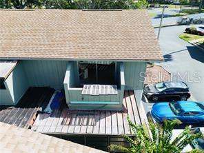 An elevated exterior view shows a building with a shingled roof and a small balcony — 1960 UNION STREET UNIT 25, CLEARWATER, FL