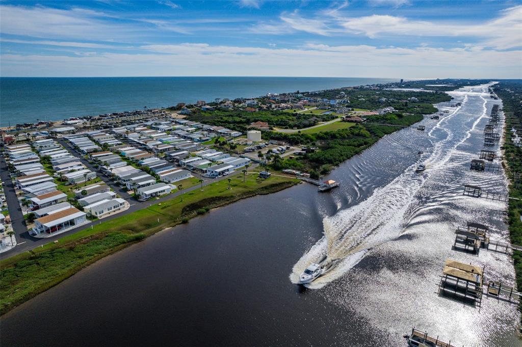 An aerial view shows a coastal mobile home community situated between the ocean and a canal — 225 STARBOARD DRIVE, FLAGLER BEACH, FL