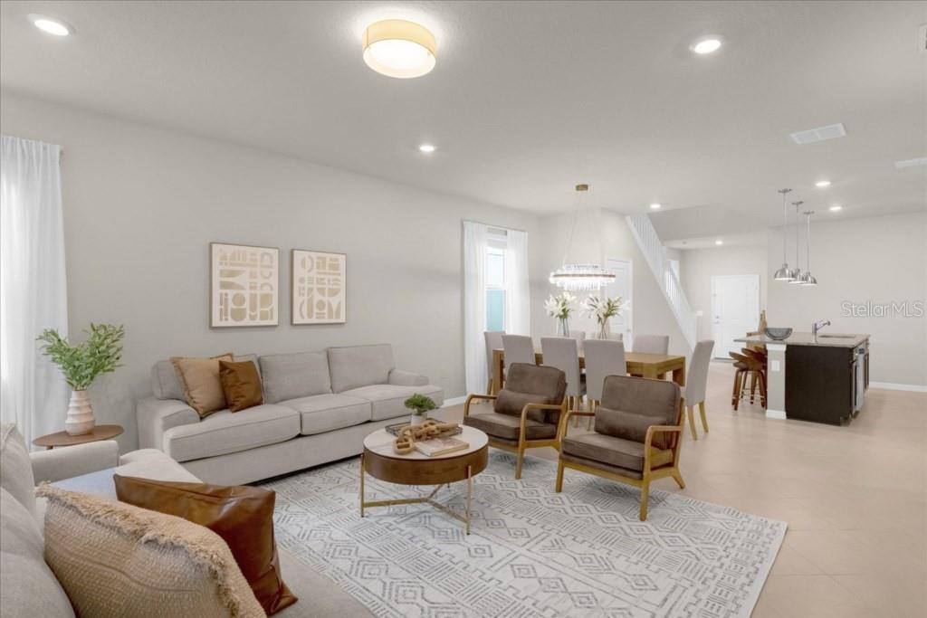 An open-concept living and dining area features neutral furniture, a patterned rug, and tile flooring — 1261 EMERALD ROW STREET, CLERMONT, FL