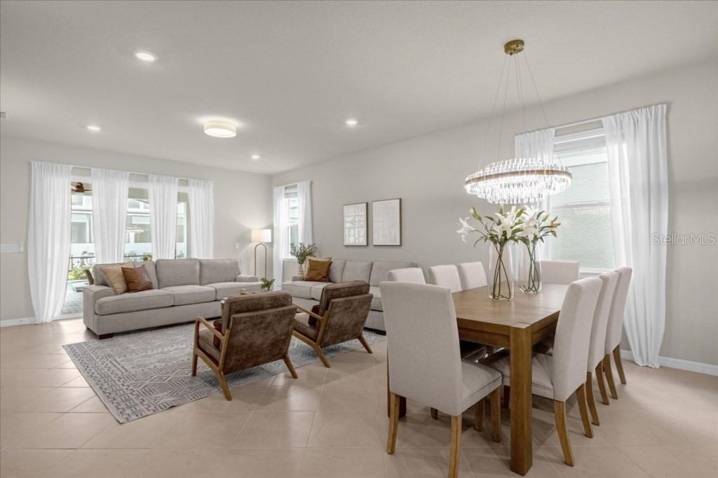 A bright open-concept living and dining area features neutral furniture, tile flooring, and a chandelier — 1261 EMERALD ROW STREET, CLERMONT, FL