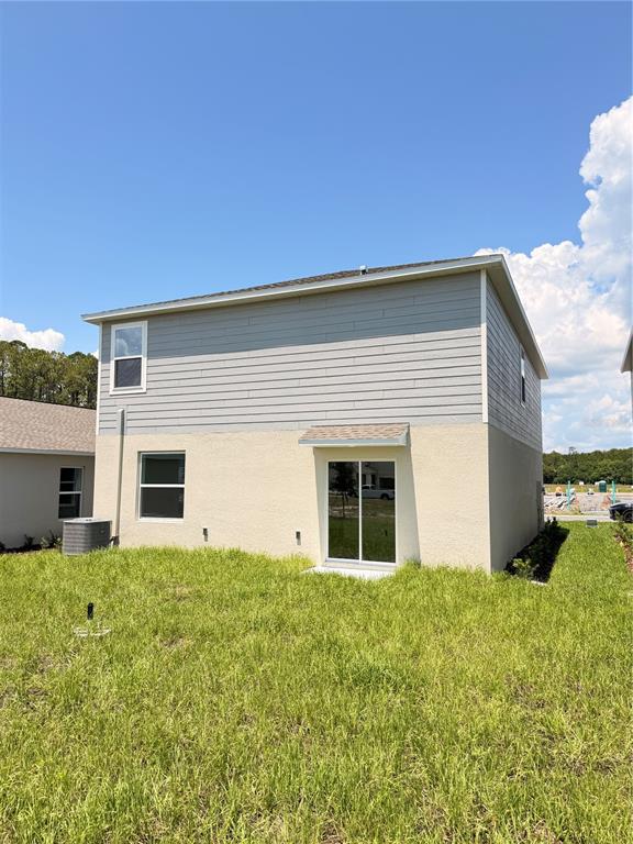 The exterior of a two-story house features light-colored stucco on the bottom and gray siding — 2466 HALLOW GARDEN RD, EUSTIS, FL