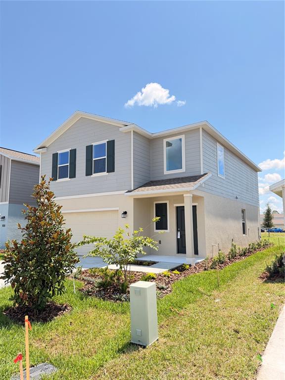 A two-story house with light gray siding, a tan stucco base, and a front-facing garage — 2466 HALLOW GARDEN RD, EUSTIS, FL