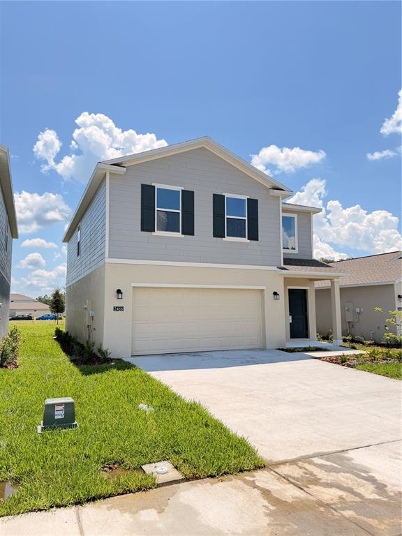 A two-story house with a beige stucco lower level, gray siding, and a two-car garage — 2466 HALLOW GARDEN RD, EUSTIS, FL