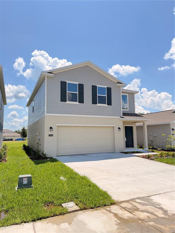 A two-story house with a light-colored stucco lower level and gray siding on the upper level — 2466 HALLOW GARDEN RD, EUSTIS, FL