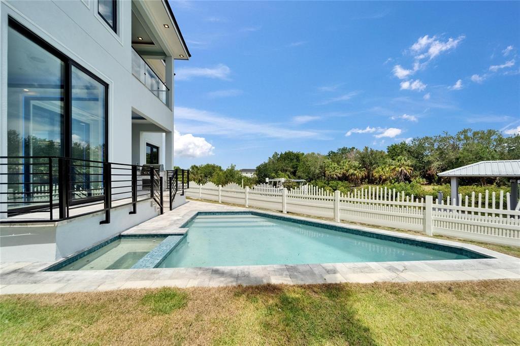 A modern house with a swimming pool and a white fence in the backyard — 6520 SIMONE SHORES CIRCLE, APOLLO BEACH, FL