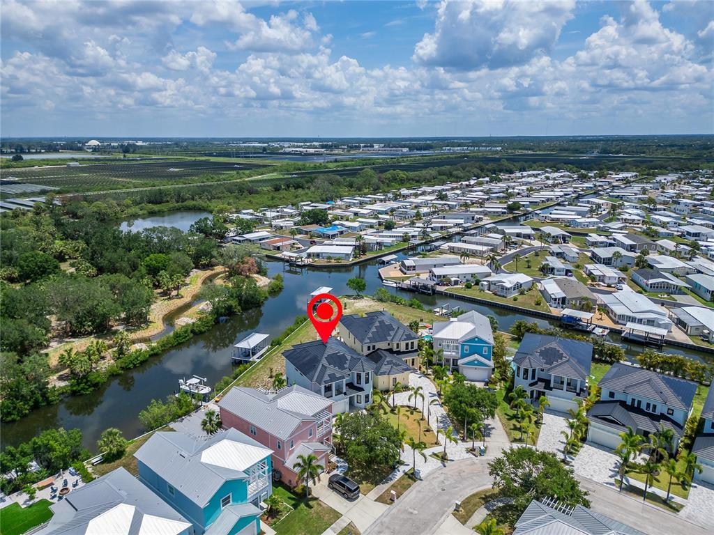 An aerial view shows a waterfront house with a red marker in a residential neighborhood — 6520 SIMONE SHORES CIRCLE, APOLLO BEACH, FL