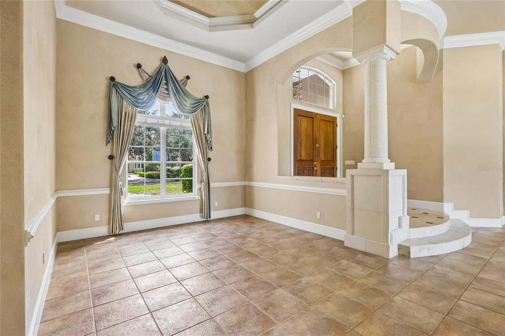 A room with tile floors, a large window with drapes, and a decorative column — 6102 S HAMPSHIRE CT, WINDERMERE, FL