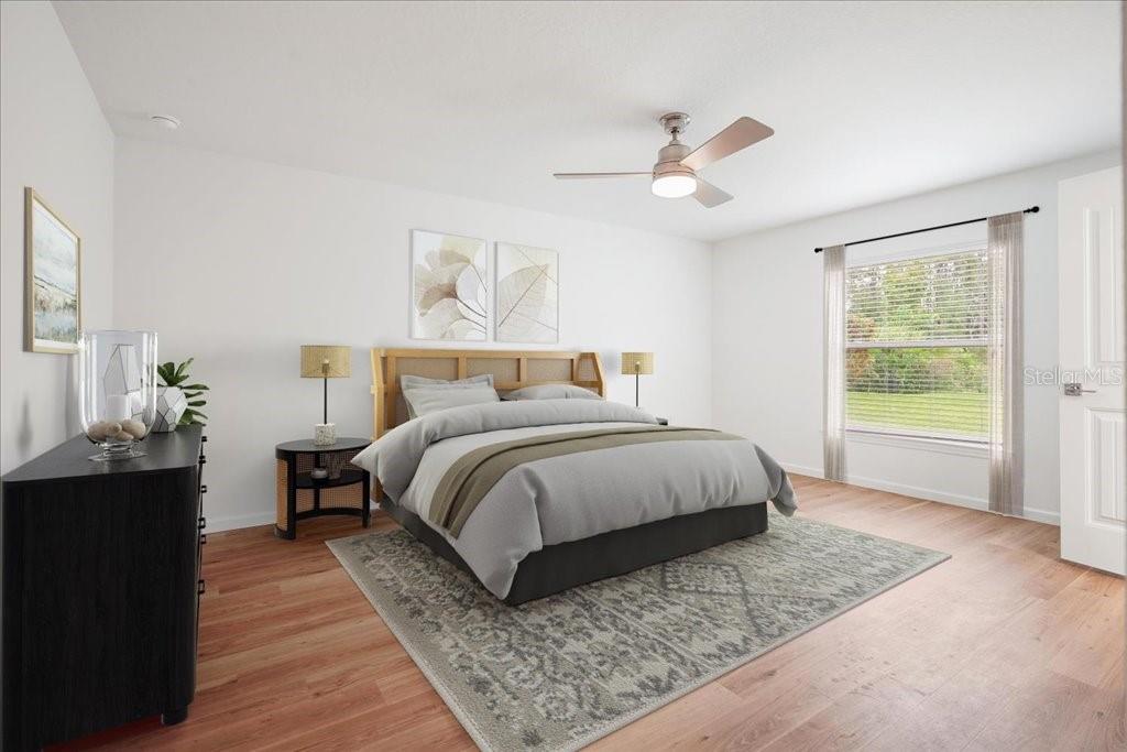 A bedroom features a bed with a wooden headboard, a ceiling fan, and hardwood floors — 36 RYMER LANE, PALM COAST, FL