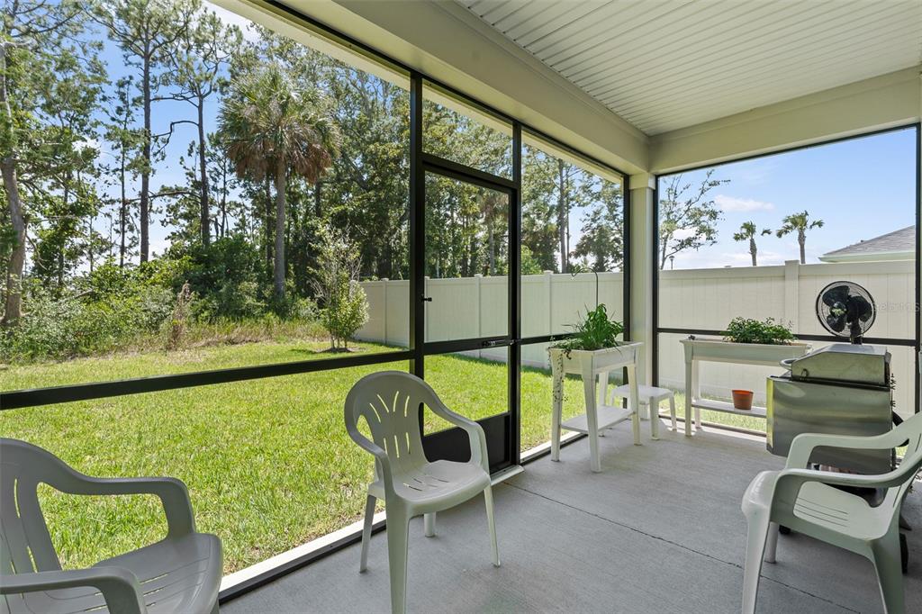 A screened-in porch with a concrete floor, a grill, and a white planter box — 6 SIGNET CIRCLE, FLAGLER BEACH, FL