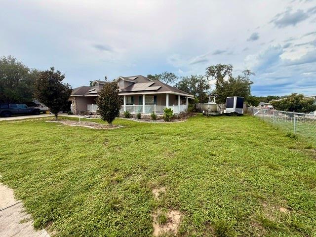 A single-story house with a porch and solar panels sits on a grassy lot — 12 E LEMON STREET, DAVENPORT, FL