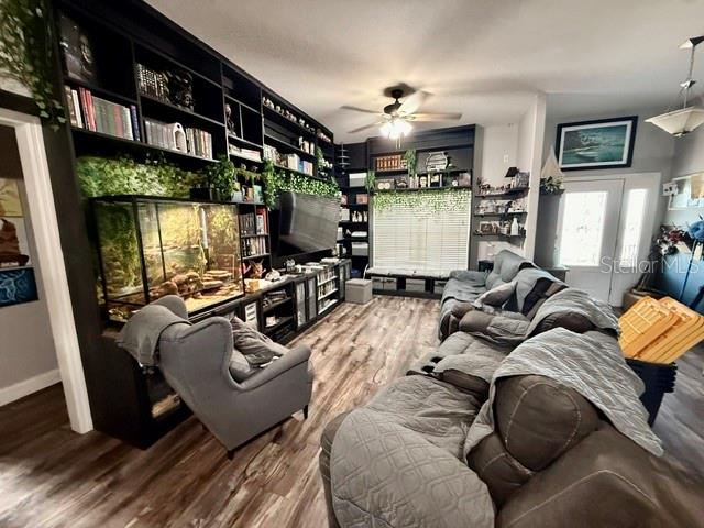 A living room features a large built-in bookshelf, a reptile enclosure, and a gray sectional sofa — 12 E LEMON STREET, DAVENPORT, FL