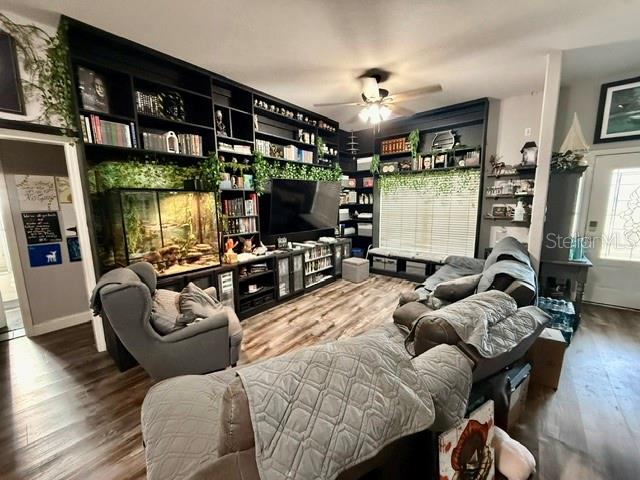 A living room features a large built-in bookshelf, a television, and a gray sectional sofa — 12 E LEMON STREET, DAVENPORT, FL