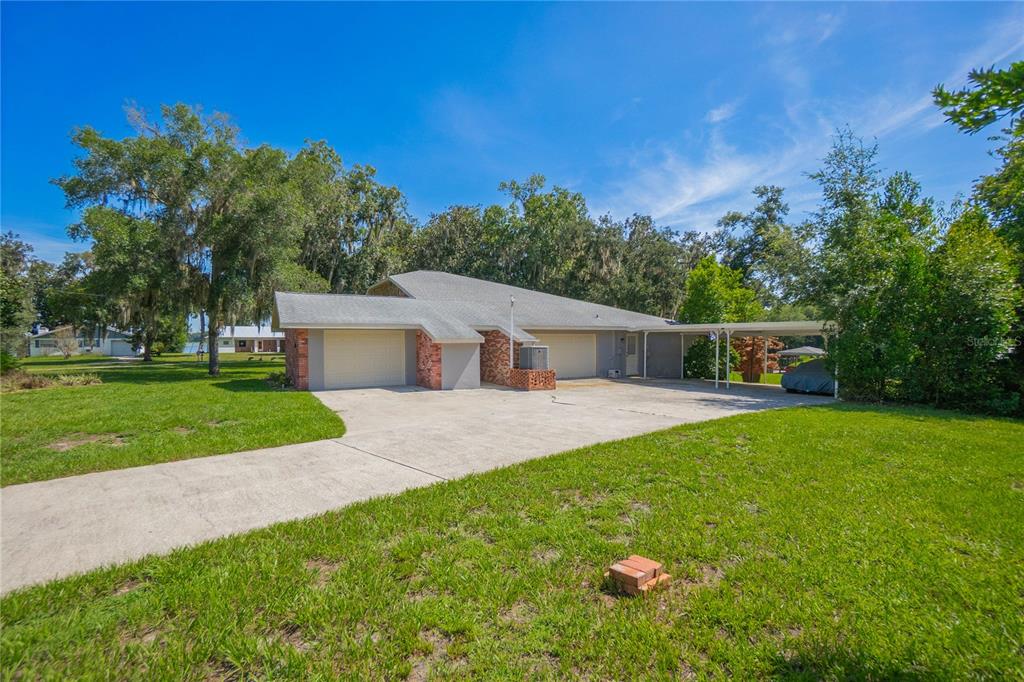 A single-story house with a two-car garage, a carport, and a large concrete driveway — 3711 E TURQUOISE DRIVE, HERNANDO, FL