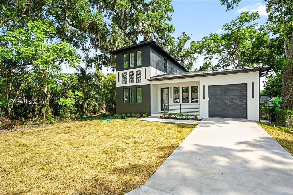A modern two-story house with a white and dark gray exterior and a single-car garage — 105 GARLAND AVENUE, SEFFNER, FL