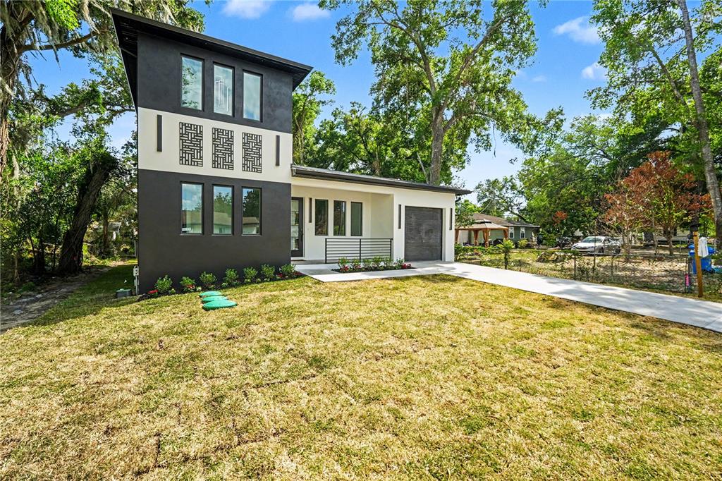 A two-story modern house with a white convertible parked on the concrete driveway — 105 GARLAND AVENUE, SEFFNER, FL