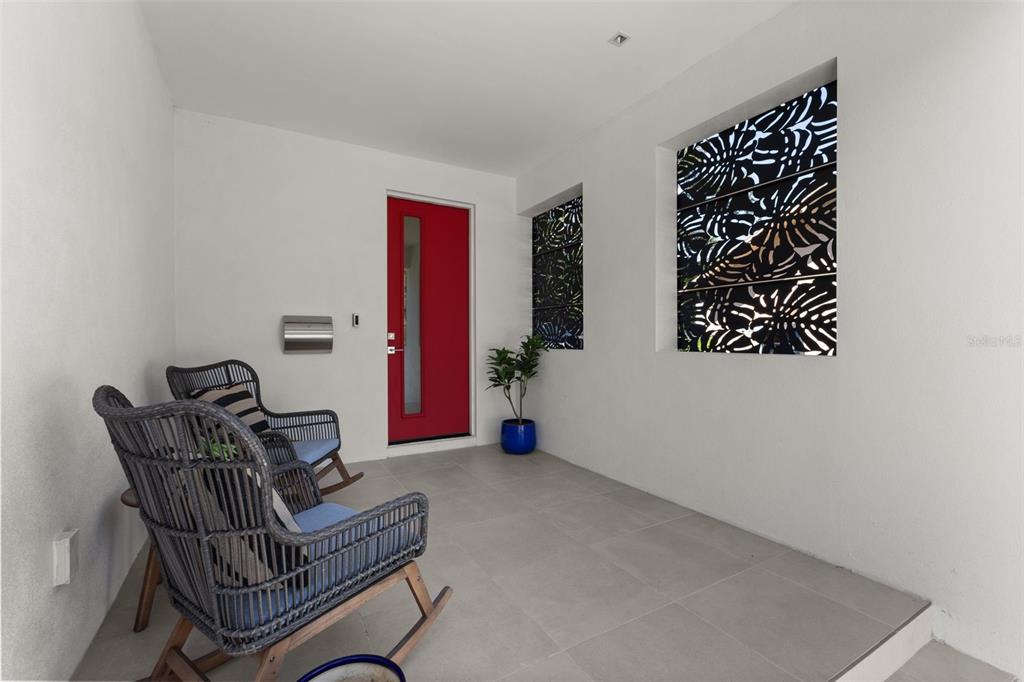 A modern living room features a white sectional sofa, a round coffee table, and sliding doors — 668 NEWTON AVENUE S, ST PETERSBURG, FL