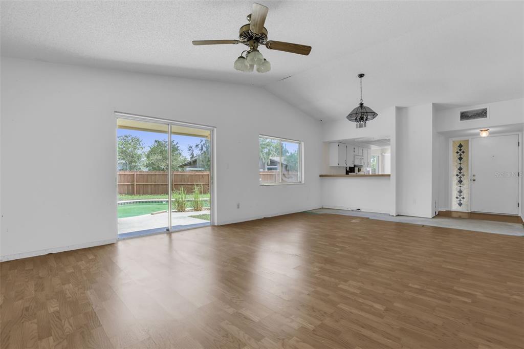 A living room with light wood flooring, a ceiling fan, and a sliding glass door — 361 KANTOR BOULEVARD, CASSELBERRY, FL