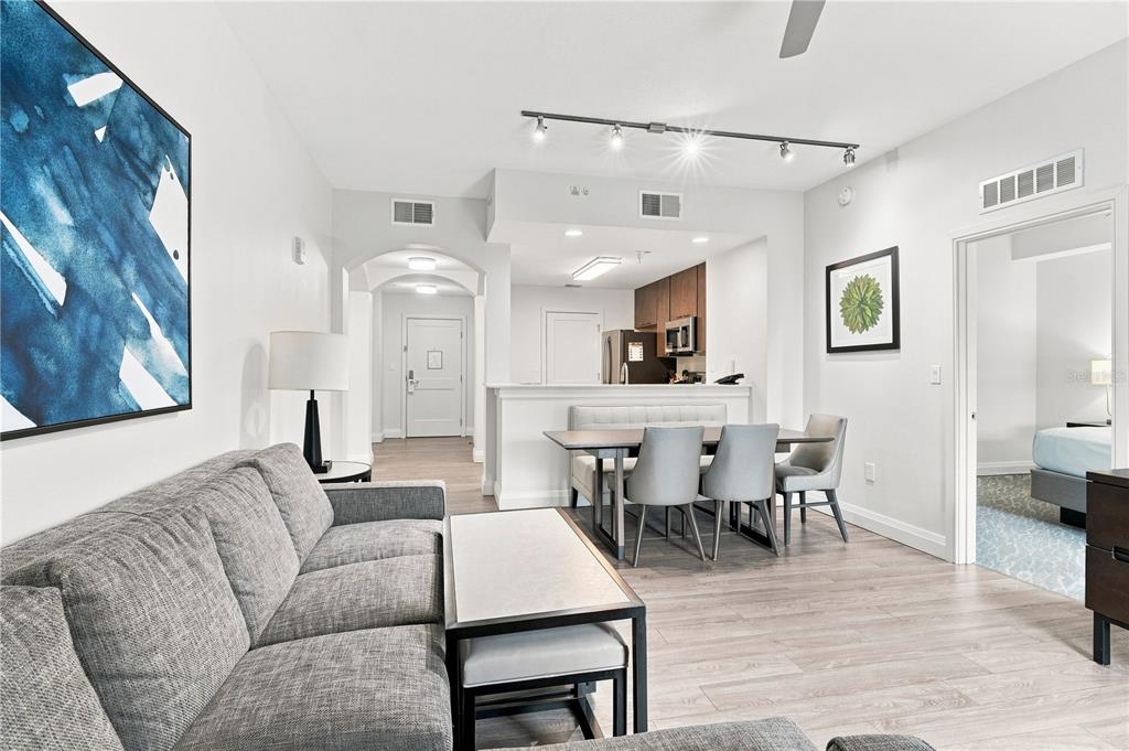 A living room with a gray sofa, dining area, and kitchen in an open floor plan — 14501 GROVE RESORT AVENUE UNIT 3403, WINTER GARDEN, FL