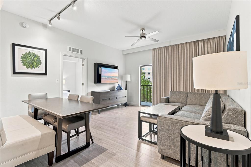 A living and dining area features light wood floors, a sectional sofa, and a balcony — 14501 GROVE RESORT AVENUE UNIT 3403, WINTER GARDEN, FL