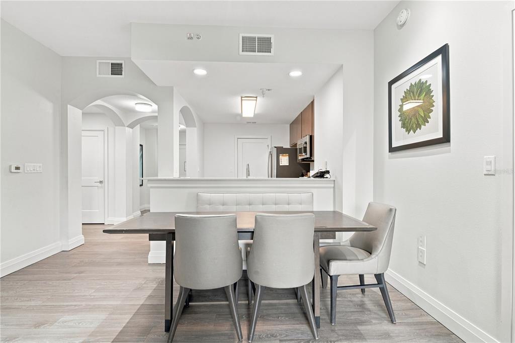 A dining area with a wooden table, four chairs, and a built-in bench seat — 14501 GROVE RESORT AVENUE UNIT 3403, WINTER GARDEN, FL