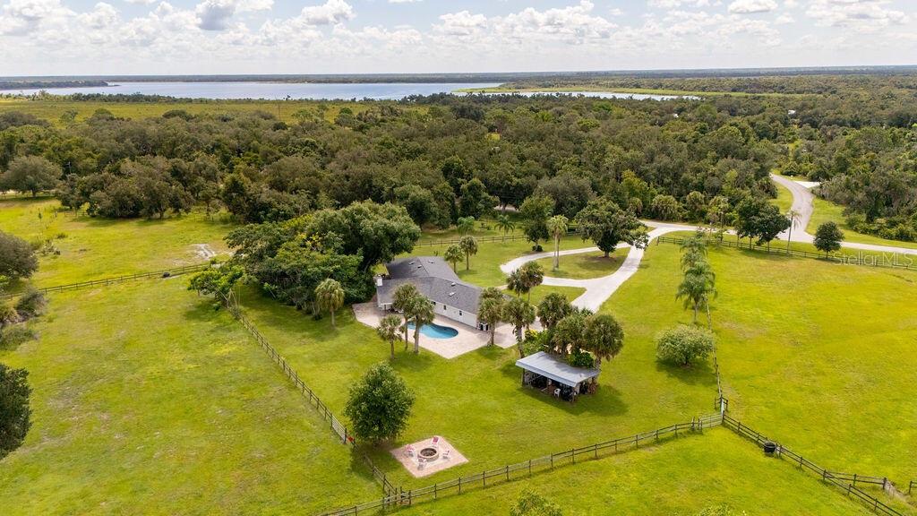 An aerial view shows a house with a pool, a detached structure, and fenced pastures — 5240 MYAKKA VALLEY TRAIL, SARASOTA, FL