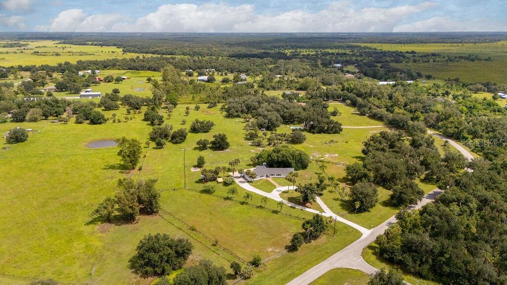 An aerial view of a house with a circular driveway surrounded by large grassy fields — 5240 MYAKKA VALLEY TRAIL, SARASOTA, FL