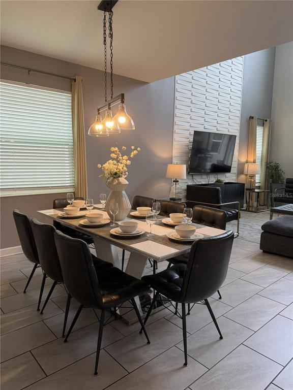 A dining room features a white table with black chairs, a chandelier, and a textured wall — 2833 BOOKMARK DRIVE, KISSIMMEE, FL