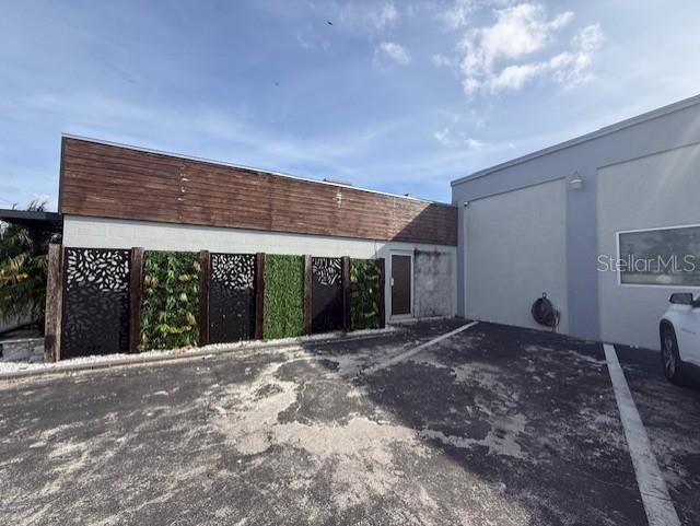 An exterior view of a building featuring a decorative privacy screen with artificial greenery — 3852 L B MCLEOD ROAD, ORLANDO, FL