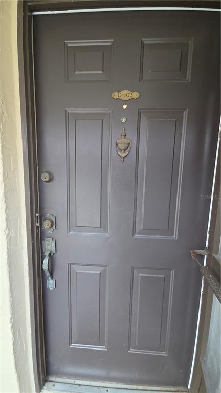 A dark brown front door with a door knocker and unit number D-103 — 100 E KENTUCKY AVENUE UNIT 103D, DELAND, FL
