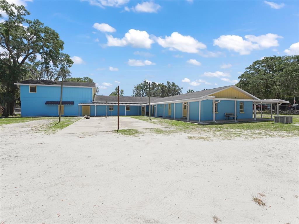 A blue, single-story building with a two-story section and a sandy yard — 9475 SE 35TH COURT, OCALA, FL