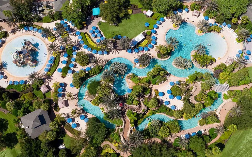 An aerial view of a resort-style swimming pool complex with a lazy river and slides — 7917 NW SPECTRUM DRIVE, KISSIMMEE, FL