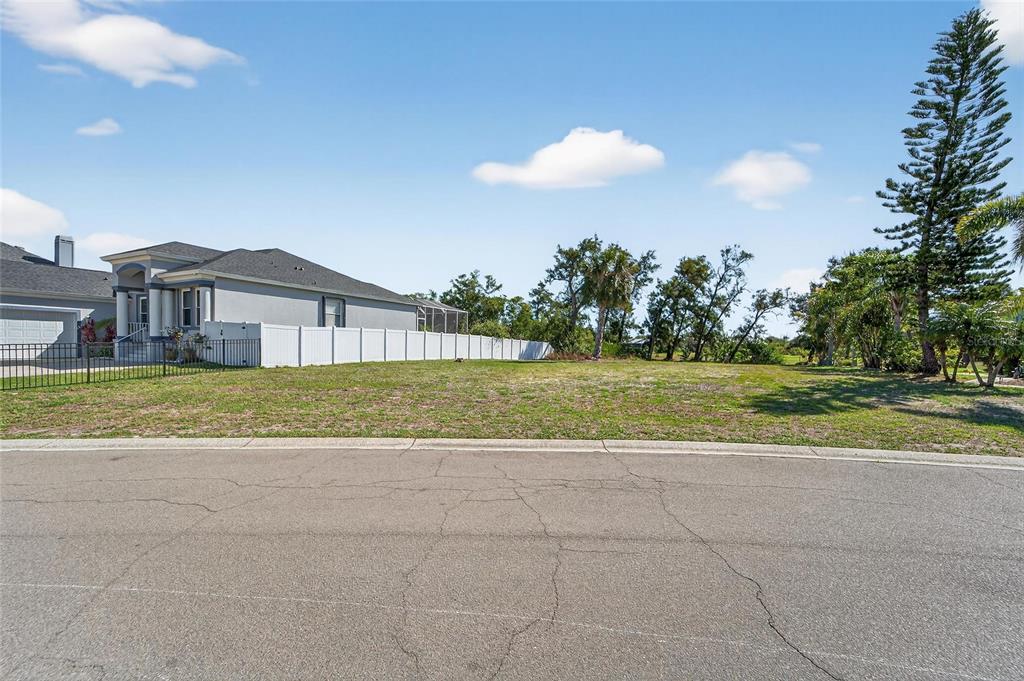 A vacant residential lot sits next to a house with a white vinyl fence — 806 GREENVIEW DRIVE, APOLLO BEACH, FL