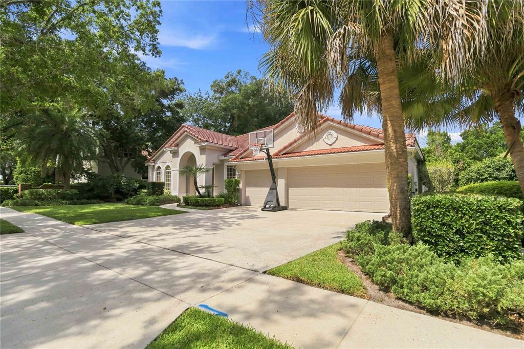 A single-story house with a tile roof, a two-car garage, and a basketball hoop outside — 1038 WESTBURY WAY, LAKE MARY, FL