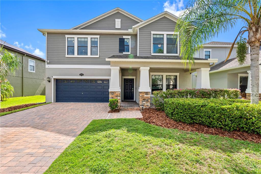 A two-story house with gray siding, a brick driveway, and a covered front porch — 19343 PADDOCK VIEW DRIVE, TAMPA, FL
