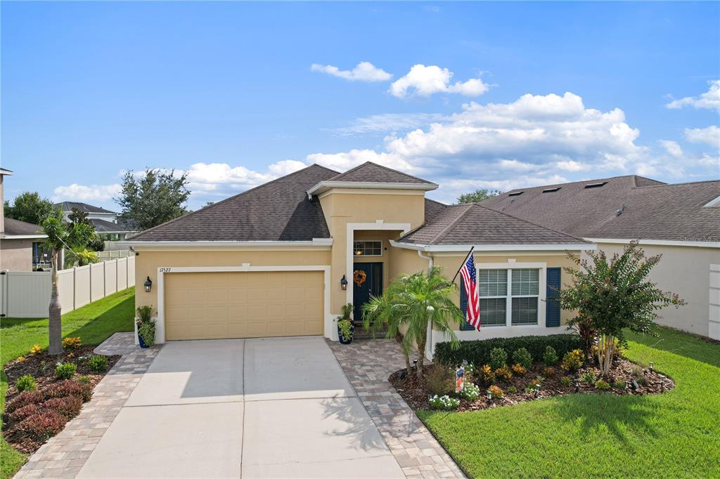 An aerial view shows a suburban house with a two-car garage facing a pond — 17527 BRIGHT WHEAT DRIVE, LITHIA, FL