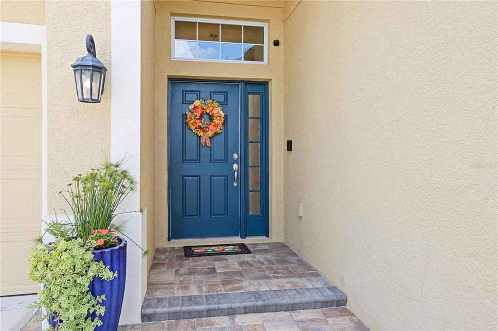 A single-story house with a tan stucco exterior, a two-car garage, and a paved walkway — 17527 BRIGHT WHEAT DRIVE, LITHIA, FL