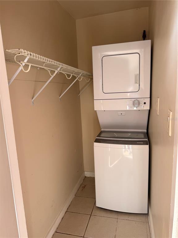 A laundry closet features a stacked washer and dryer unit and a wire wall shelf — 21038 VOYAGER BOULEVARD UNIT 4, LAND O LAKES, FL