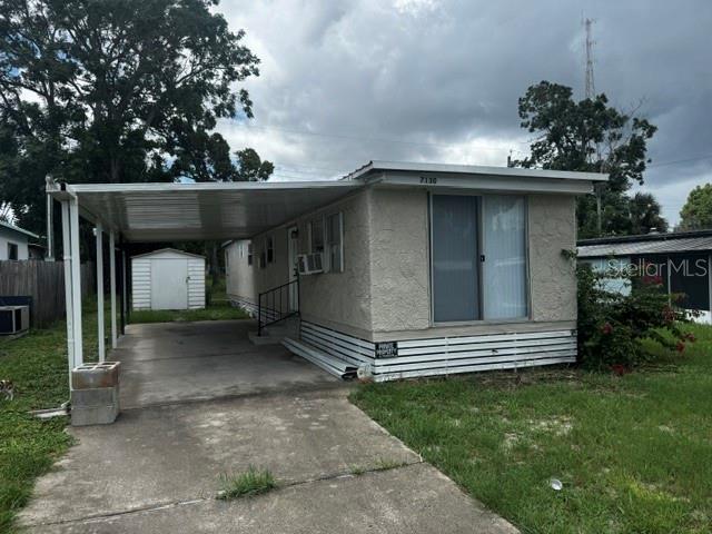 A single-story mobile home with a carport and a small shed in the backyard — 7130 COMMONS BOULEVARD, PORT RICHEY, FL